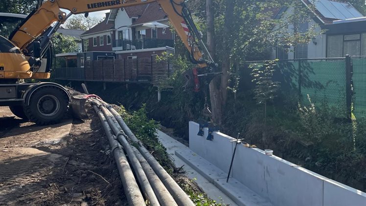 het plaatsen van de damwanden in de beek