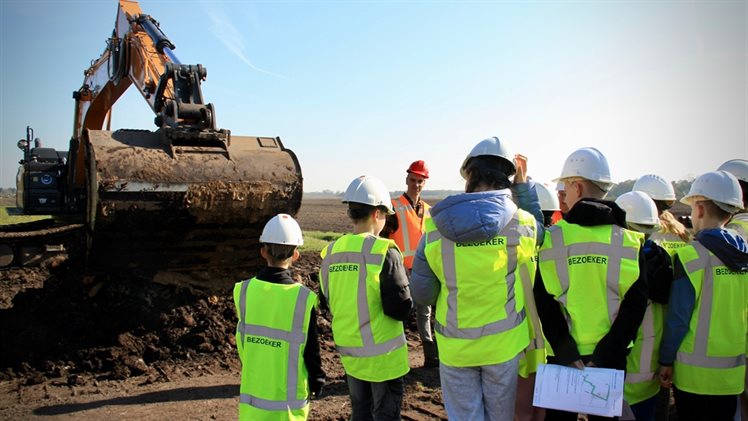 Op de werklocatie legde aannemer Nonak aan de kinderen uit wat daar gebeurt.